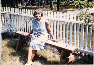 Portrait of Dorothy West seated outdoors on a bench