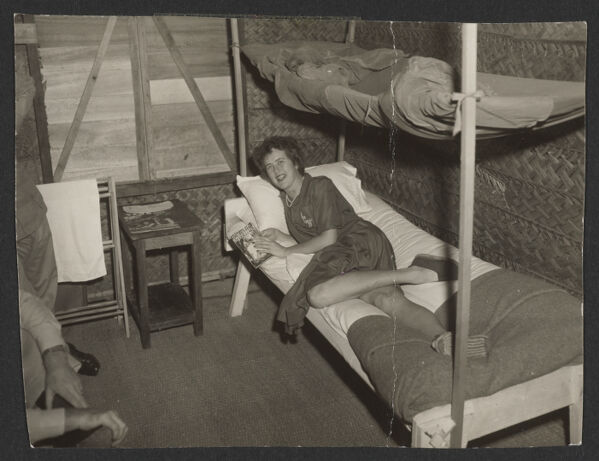 Julia Child lounging on her cot in the OSS headquarters, reading an issue of Health & Efficiency