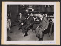 8x10 Black and White mounted on 8 1/2x11 1/4 piece of cardboard. On back the label reads, &quot;From left to right Mr. [Willbert C.] Petty and Mr. Prillaman of the American Cultural Center, Mr. Alphonse Boni [Ivorian] Supreme Court, and Dean Ferguson during a discussion held November 11 with members of the Ivorian Supreme Court.&quot; Ca. early 1960s. Front (bottom right) is signed &quot; T.H.[unreadable] - Howard.&quot; Digital Object