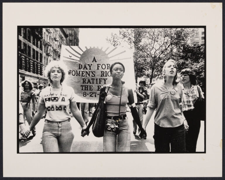 Group of women, arms linked, marching