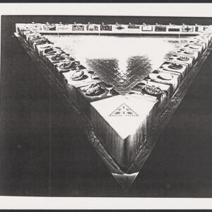 A black and white photocopy of a photograph of a triangular table lined with place settings and open in the center