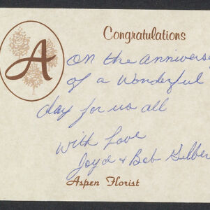 Handwritten note in blue ink on beige Aspen Florist card with brown printed logo and text