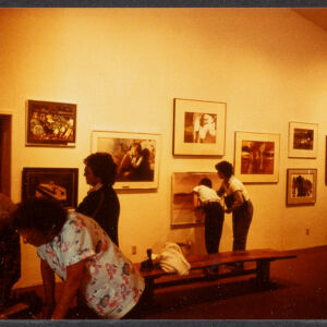 Color photograph of people viewing an exhibition of artworks on a wall