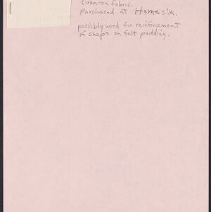 Small rectangle of white fabric attached to pink paper with handwritten annotations in pencil
