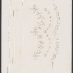 White embroidery of a vegetal pattern and a scalloped edge on white fabric attached to a white piece of paper