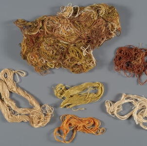 Six samples of embroidery thread in shades of rust, orange, beige, and light brown The largest sample at the top is in a mix of different colors