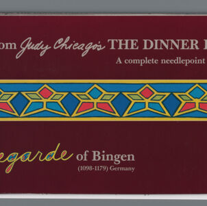 Packaging for a needlepoint kit with a multicolored, horizontal star motif on a burgundy ground with light gray type