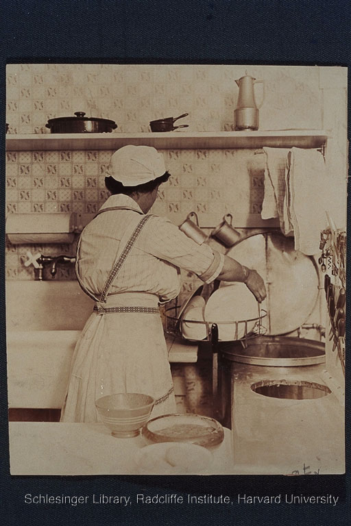 Portrait of an unidentified woman loading a dishwasher, Applecroft Home Experiment Station kitchen.