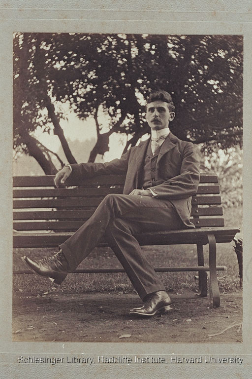 Unidentified man sitting outdoors on a bench.