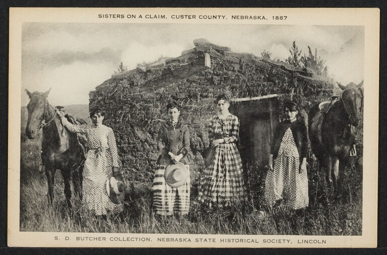 Four women on a claim in Nebraska, outside a sod house with two horses