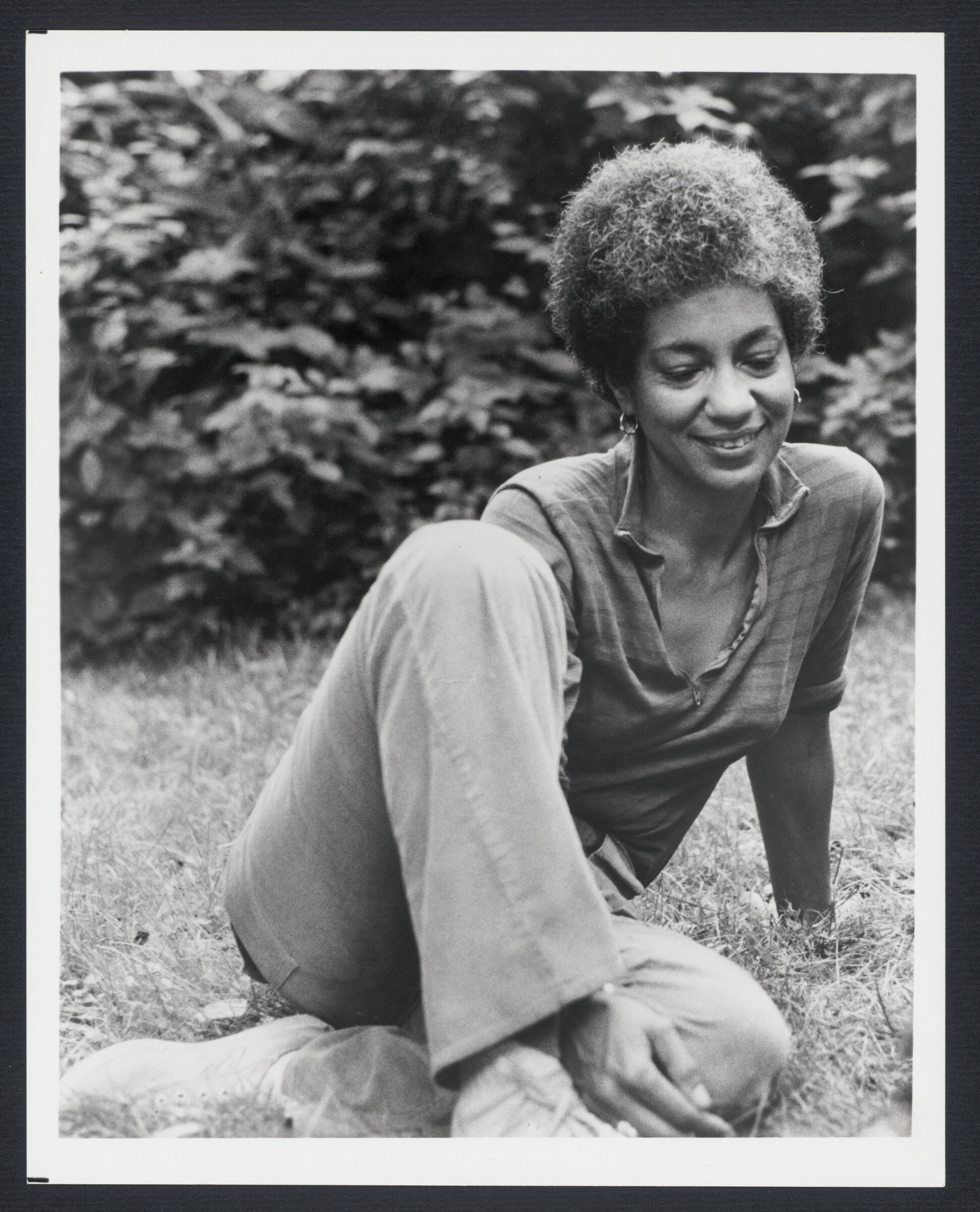 Portrait of June Jordan seated outdoors in grass, c.1970-1975