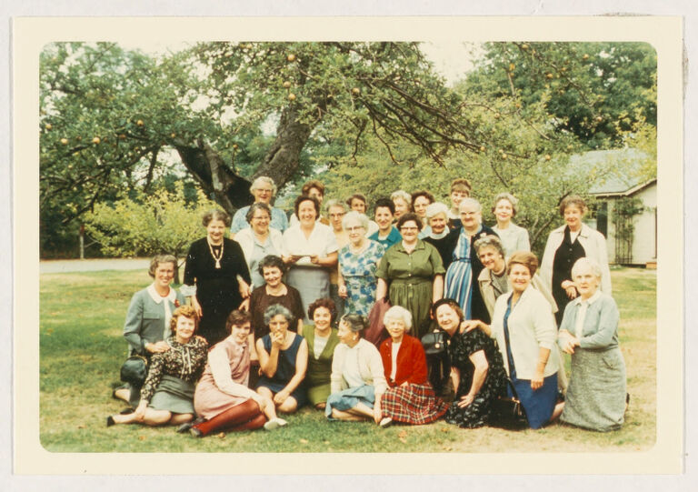 Group portrait, outdoors, of members of the Women's Educational and Industrial Union (some standing, some seated on the grass)