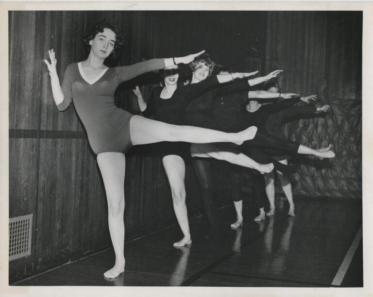 women dancing in leotards, balancing against a wall.