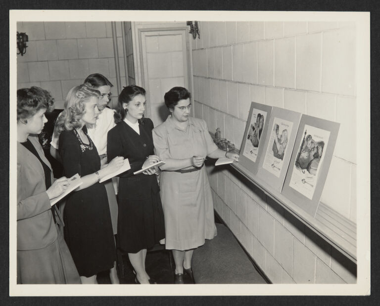  Jean Wade Rindlaub and Junior Council Women looking at advertising panels, taking notes