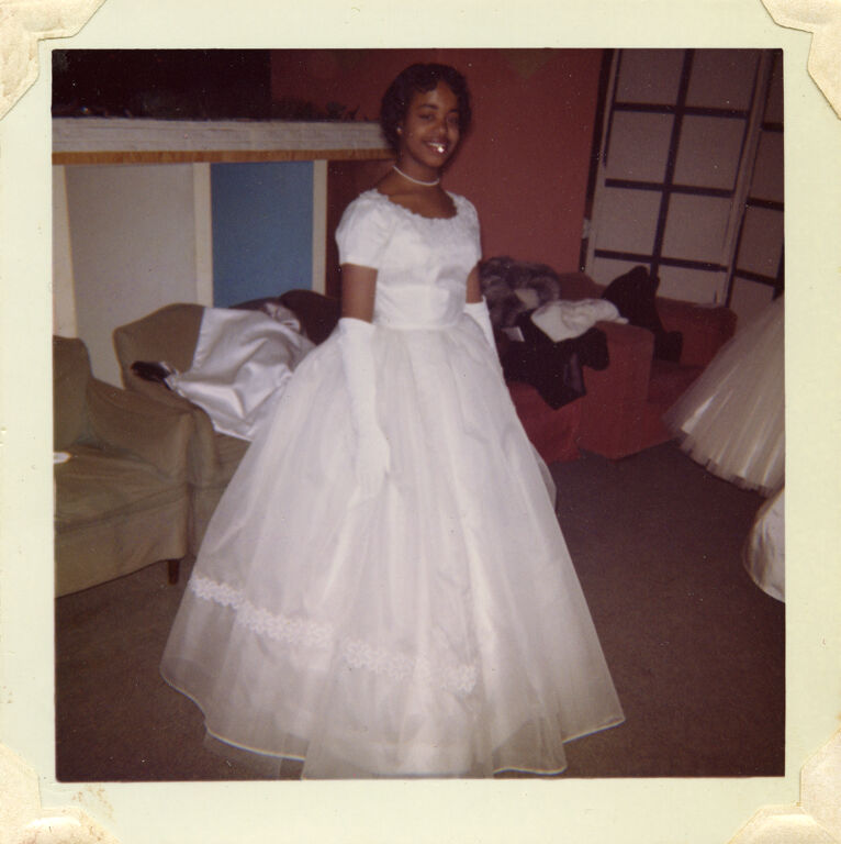 Portrait of a young African American debutante in a white ball gown.