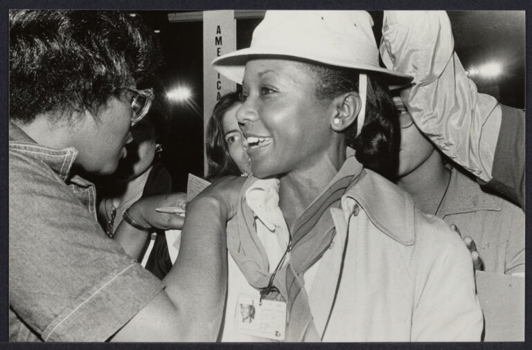Mildred Jefferson, wearing a hat, surrounded by people at a conference.
