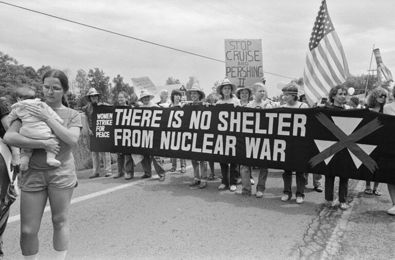 Women holding a banner that reads "Women strike for peace: There is no shelter from nuclear war"