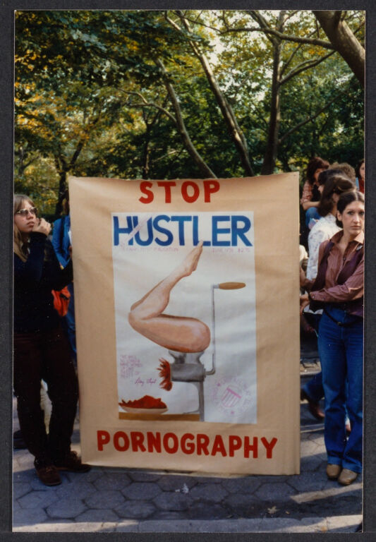 Two women holding poster featuring the cover of June 1978 Hustler "all-meat" issue at anti-pornography protest, ca.1979