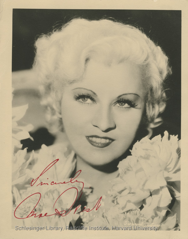 Signed publicity photo of Mae West looking out of the corner of her eye and smiling. 