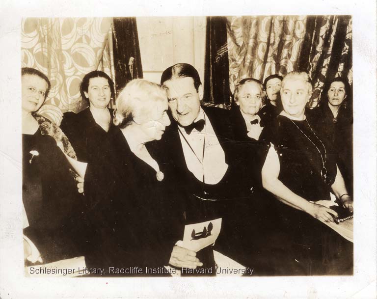 Henrietta Szold, Stephen Wise, and others at Hadassah Convention ca. 1930-1940. They are sitting in a group of people, leaning into each other and talking amongst themselves. They are wearing dress clothes.